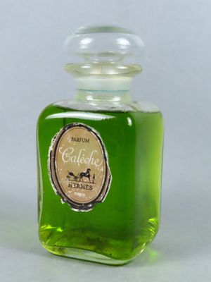 une bouteille contenant un liquide vert posée sur une surface blanche