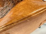 a close up of a brown leather bag with a handle