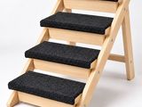 a close up of a set of stairs with black carpet
