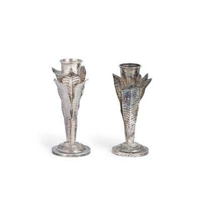 deux vases en argent posés l'un à côté de l'autre sur une surface blanche