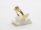 a close up of a gold ring with a diamond on top