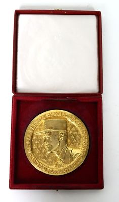 an image of a gold medal in a red box on a white surface