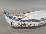 a small boat shaped dish with a floral design on it