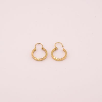 une paire de boucles d'oreilles en or sur fond blanc