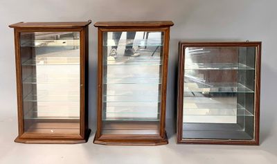 three wooden display cases with glass doors on a white surface