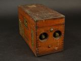 a small wooden box with two bottles inside of it