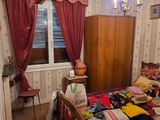 a bedroom with a bed, dresser and a chandelier in it