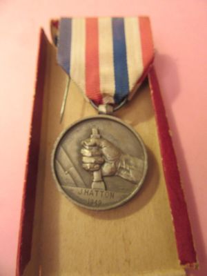 une médaille dans une boîte, entourée d'un ruban