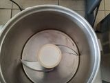 a metal bowl with a spoon inside of it on a tiled floor