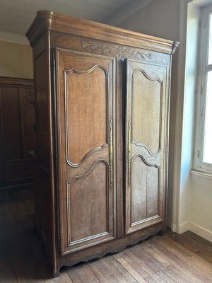 une grande armoire en bois dans le coin d'une pièce