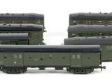 three green train cars sitting next to each other on a white surface