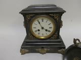 a small clock sitting next to a small clock on a table