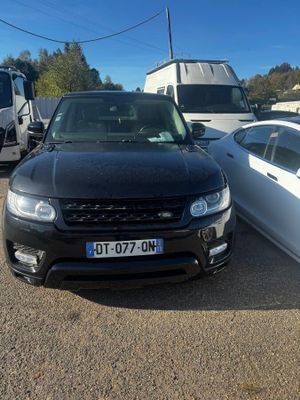 cars are parked in a lot with a trailer in the background