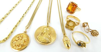 several gold necklaces, rings, rings, and pendants on a white surface