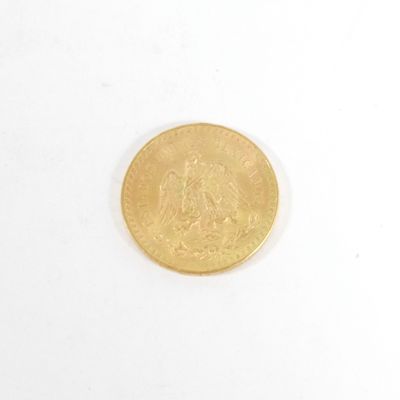 une pièce d'or sur une surface blanche avec un fond blanc
