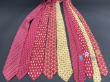 four different colored ties are tied together on a black surface