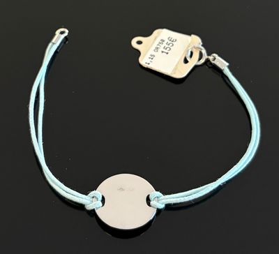 un gros plan d'un bracelet posé sur une surface noire, avec une étiquette