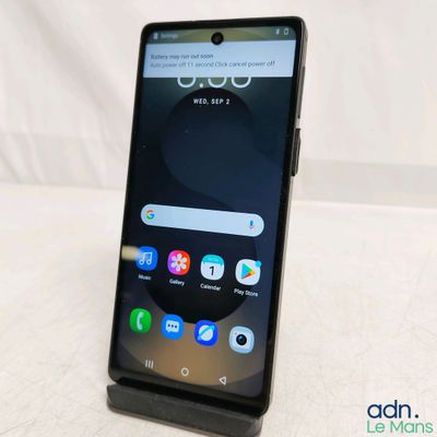 un gros plan d'un téléphone portable posé sur une table, sur fond blanc