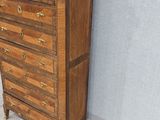 a tall wooden chest of drawers with marble top