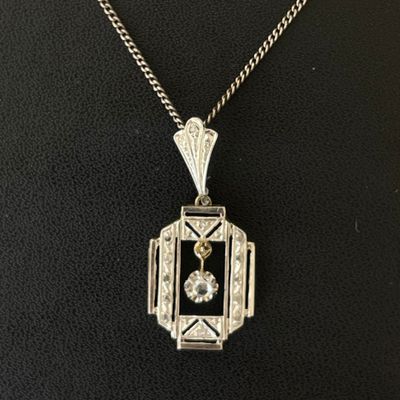 an art deco pendant with a diamond set in the center