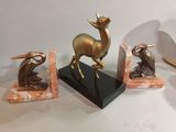 three statues of a deer, a bird, and a bird on a marble base
