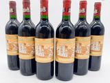 six bouteilles de vin sont alignées sur une surface blanche
