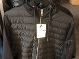 une veste noire suspendue à un portant dans un magasin de vêtements