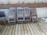 four chairs sitting on a wooden deck next to a planter