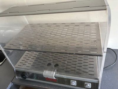 un plan de travail argenté surmonté d'une grille métallique