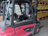 a red fork truck parked in a warehouse with pallets