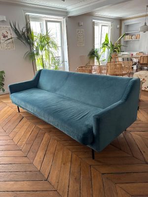une photo d'un salon avec un canapé bleu