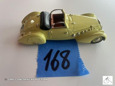 une petite voiture jaune posée sur un tissu bleu