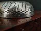 a silver object sitting on top of a wooden table