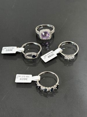 four different rings with tags on them sitting on a table