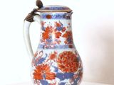un vase bleu et rouge posé sur une table blanche