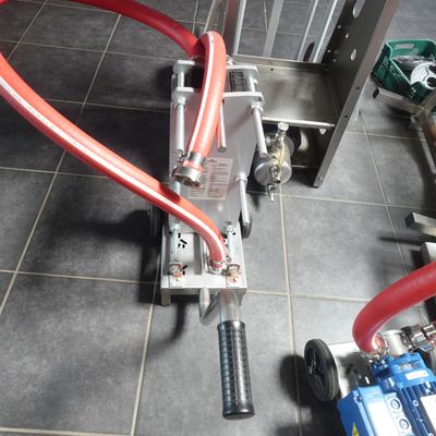 un tuyau rouge raccordé à une machine posée au sol