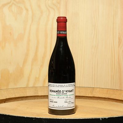 a bottle of wine sitting on top of a barrel