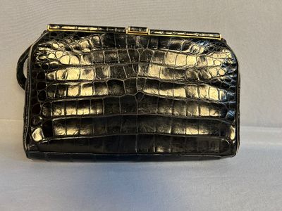 un sac à main en cuir de crocodile noir sur fond blanc