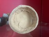 a clay object that is sitting on a glass table