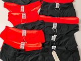 trois paires de sous-vêtements rouges et noirs posées sur une surface blanche