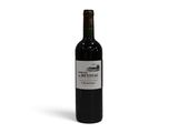 la bouteille de vin rouge est posée sur une surface blanche