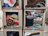 trois cartons remplis de vêtements, empilés les uns sur les autres