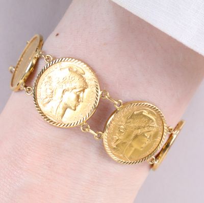 bracelet en pièces d'or au poignet d'une femme, avec une pièce au centre