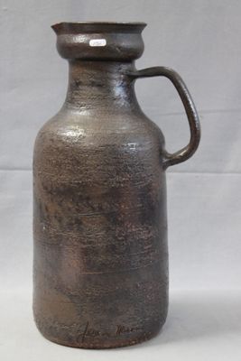 un vase brun avec une anse sur fond blanc