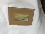 the back of a white purse with a gold plate on the front of it