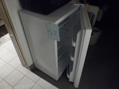 un petit réfrigérateur dont la porte est ouverte dans une cuisine