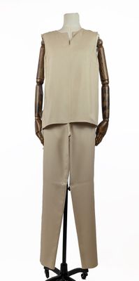 Le mannequin porte un costume beige et un pantalon beige.