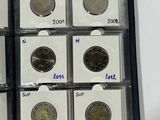 several coins are in a display case on a white surface