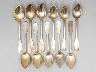 six cuillères en argent et deux cuillères en argent sur une table