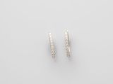 a pair of diamond hoop earrings on a white background